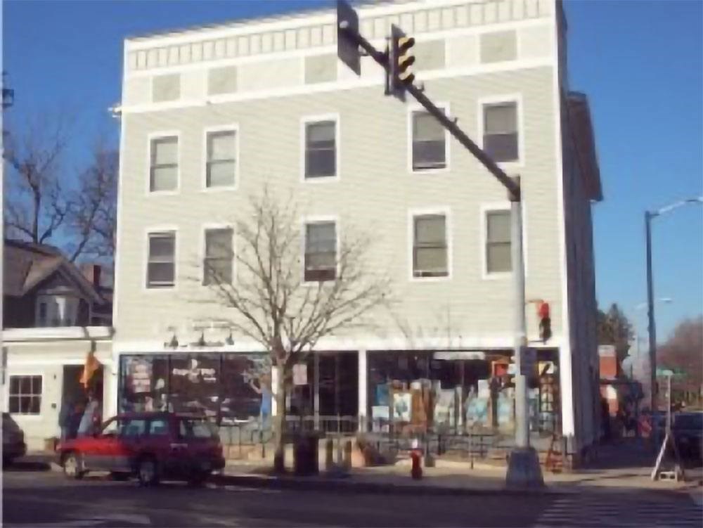 A white building with a red car in front of it.