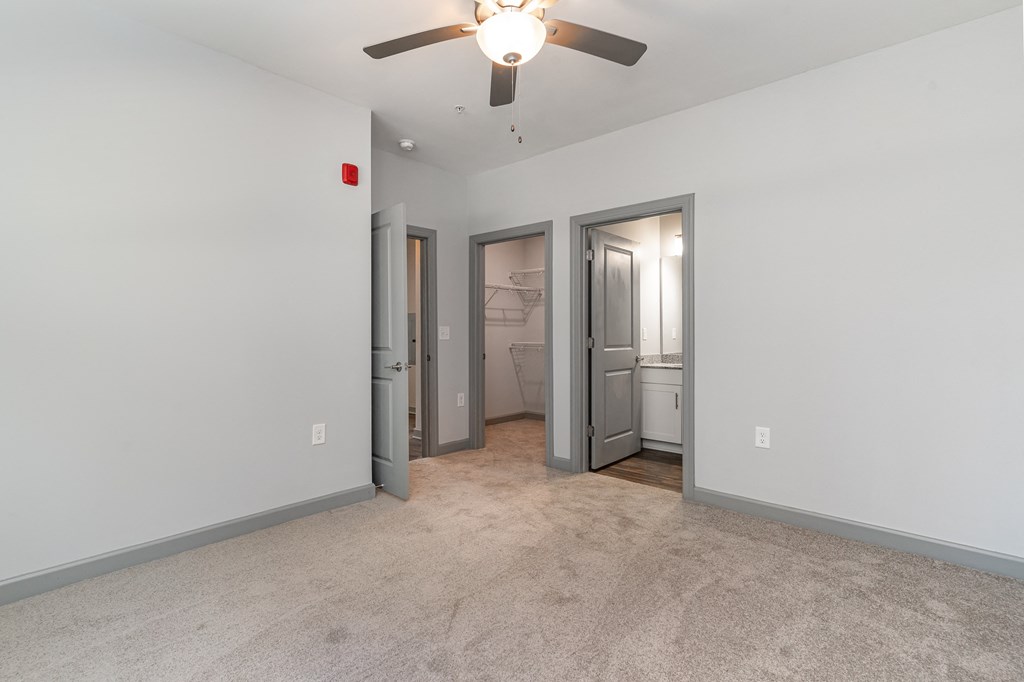 a bedroom with a ceiling fan and a closet with two doors at The Parker Myrtle Beach, Myrtle Beach, SC
