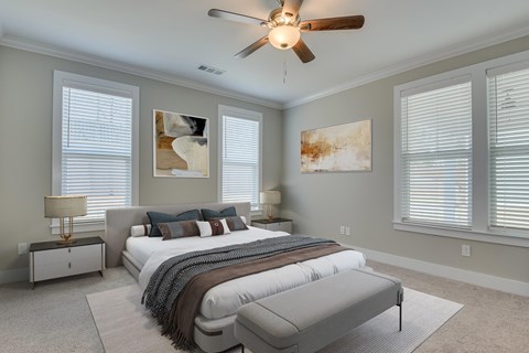 A bedroom with a large bed and a ceiling fan.