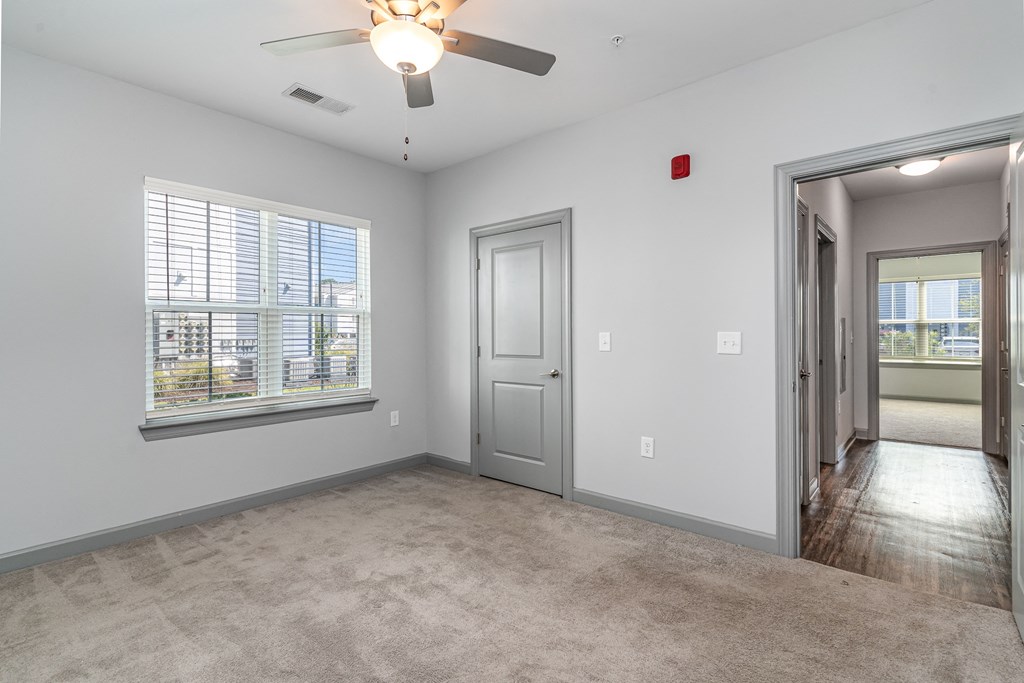 a bedroom with a ceiling fan and a large window at The Parker Myrtle Beach, South Carolina, 29588