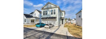 Two cars parked in front of a house.