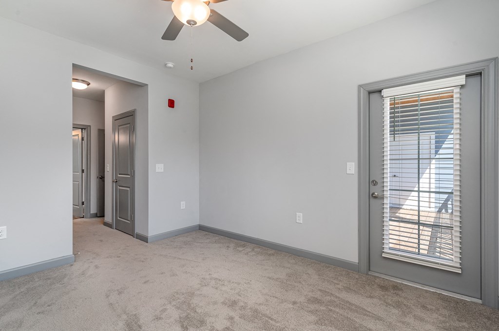 a bedroom with a ceiling fan and a door to a balcony at The Parker Myrtle Beach, Myrtle Beach, SC