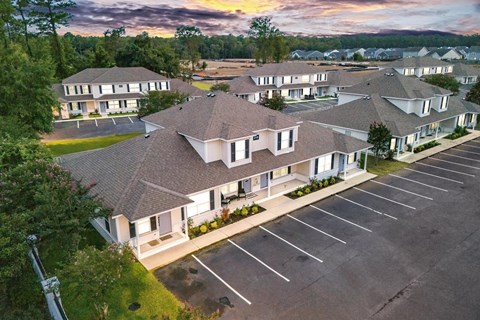 A large building complex with a parking lot in front.