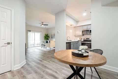 A modern kitchen with a wooden table and chairs in the foreground.