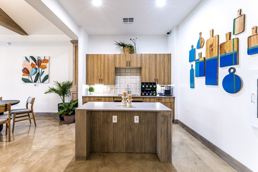 a kitchen with wooden cabinets and a marble counter top at The Parker Austin, Pflugerville, 78660
