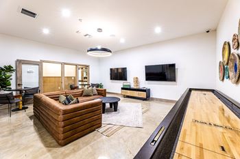 a living room with a bowling alley and a tv at The Parker Austin, Pflugerville, TX, 78660