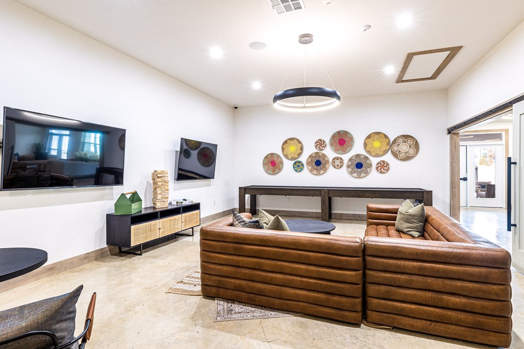 a living room with couches and a tv at The Parker Austin, Pflugerville, TX