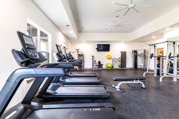 a gym with cardio equipment and weights on the floor at The Parker Austin, Texas