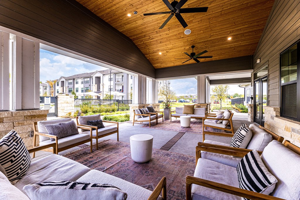 a covered patio with couches and chairs and a tv at The Parker Austin, Texas