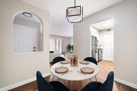 A dining room with a white table and black chairs.