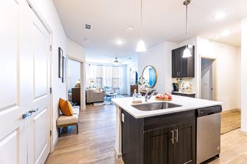 a kitchen with an island and a living room at The Parker Austin, Pflugerville, 78660