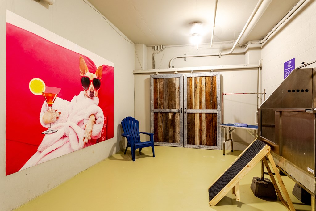 a room with a large poster of a woman wearing sunglasses and holding a drink at 500 Fifth Apartments, Nashville