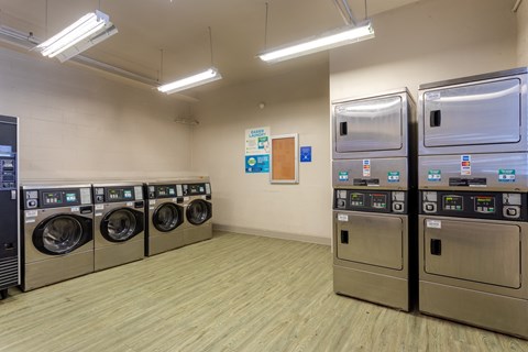 Laundry room with a row of washing machines and refrigerators at 500 Fifth Apartments, Tennessee, 37219