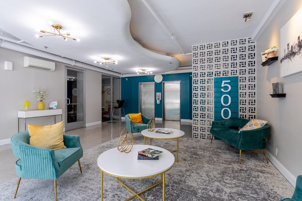 a living room with blue and yellow furniture and a lobby with a 50o sign at 500 Fifth Apartments, Nashville, TN
