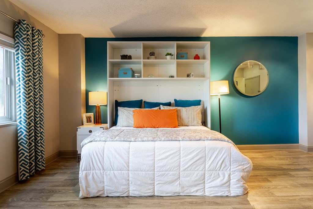 a bedroom with a bed and a blue wall and a window at 500 Fifth Apartments, Nashville