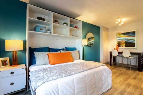 Bedroom with a bed and a desk and a mirror at 500 Fifth Apartments, Nashville, Tennessee