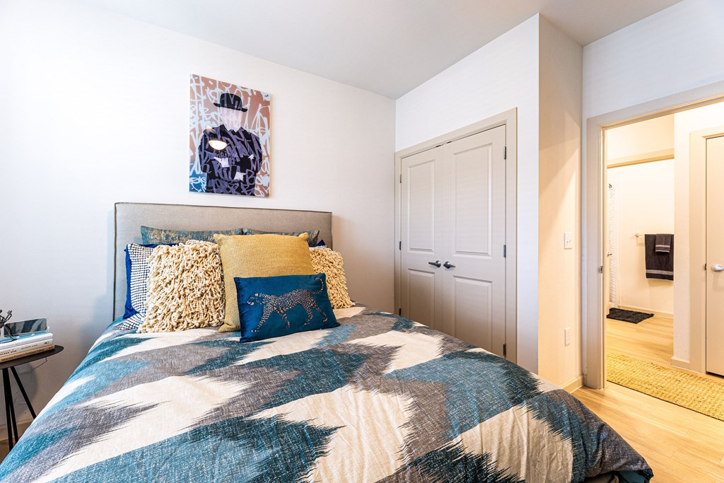 a bedroom with a bed and a door to a bathroom at The Parker Austin, Pflugerville, Texas