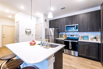 a kitchen with stainless steel appliances and a white counter top at The Parker Austin, Texas