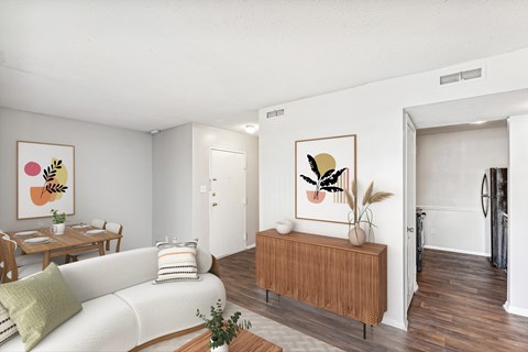 A living room with a white couch and a wooden bench.
