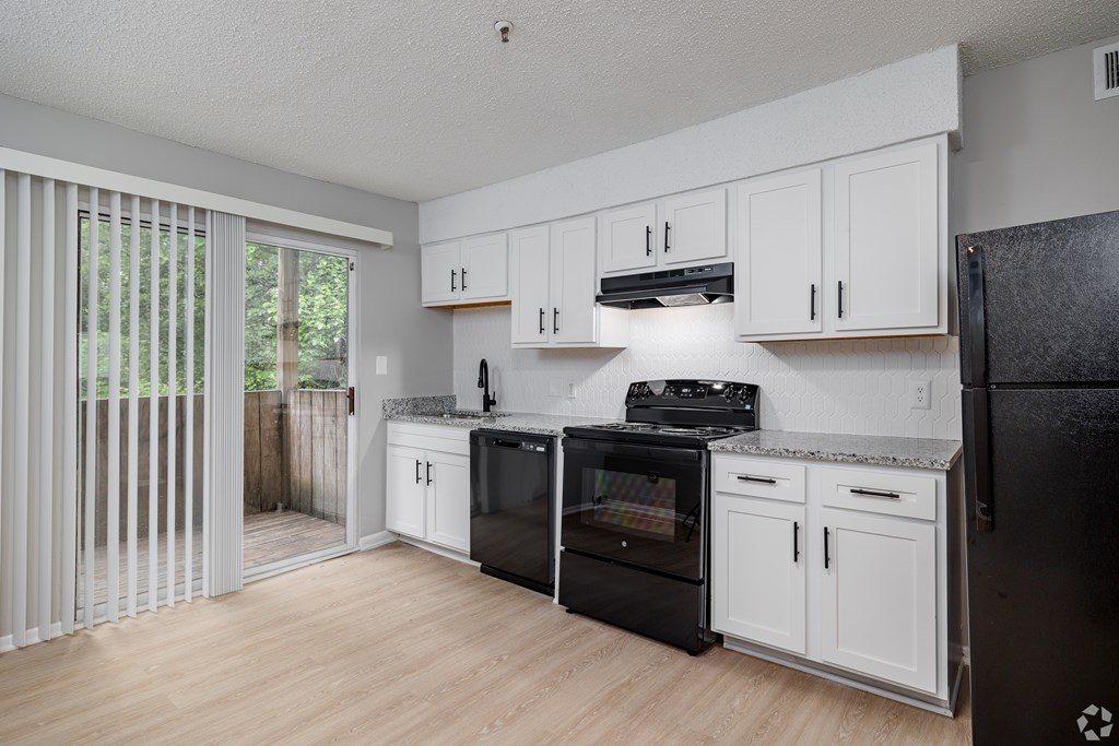 A Kitchen With Black Appliances at Avondale Place Apartments, Avondale Estates, 30002