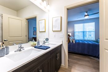 a bathroom with a large mirror and a bed in a room at The Parker Austin, Pflugerville, TX, 78660