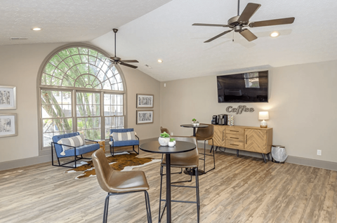 A living room with a round table and chairs, a sofa, and a television.