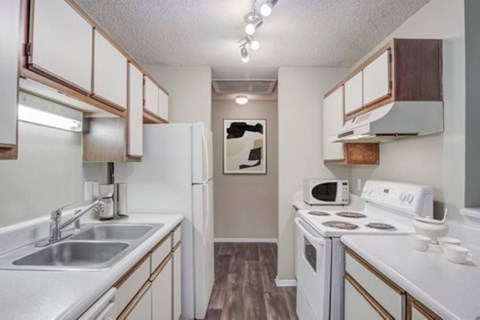 A small kitchen with white appliances and wooden cabinets.