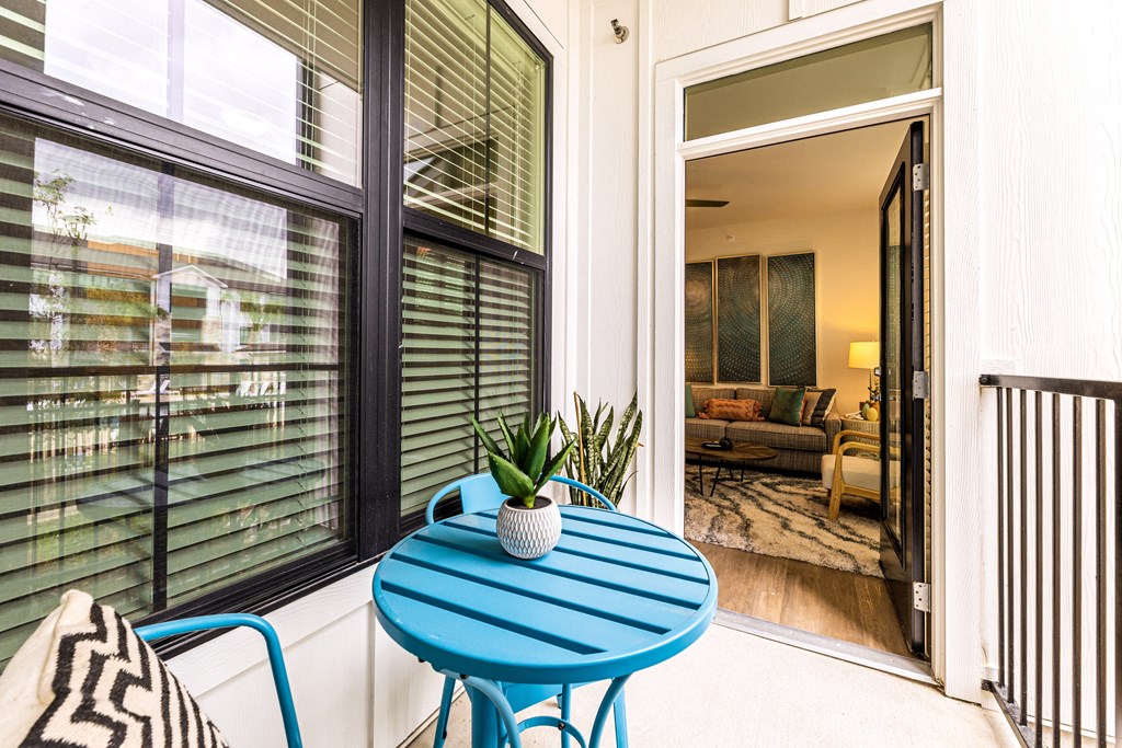 a small patio with a blue table and chairs at The Parker Austin, Pflugerville, 78660