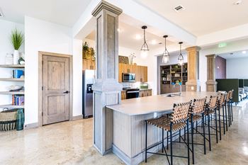 a large kitchen with a large island and bar chairs at The Parker Austin, Pflugerville, TX, 78660