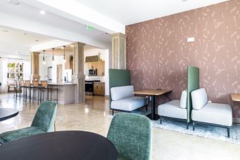a lobby with chairs and tables and a kitchen at The Parker Austin, Pflugerville, Texas