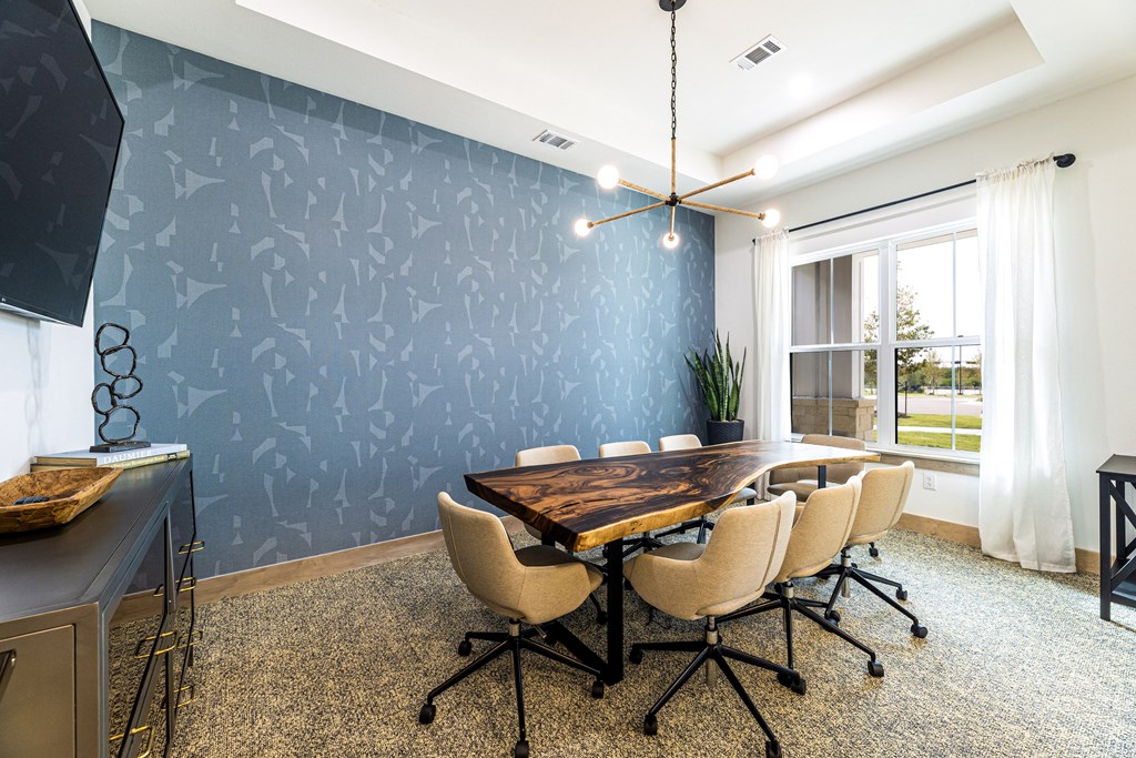 a conference room with a large table and chairs and a blue wall at The Parker Austin, Pflugerville, Texas