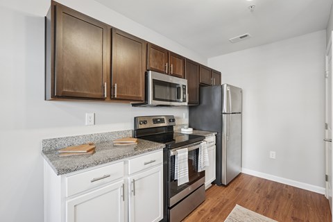 A kitchen with white cabinets and a granite countertop.