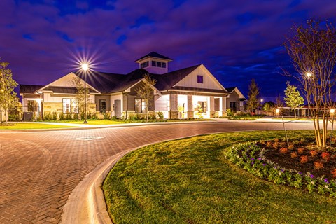 a house with a driveway and a street at night