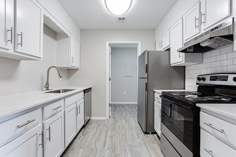 A kitchen with white cabinets and a black stove top oven.