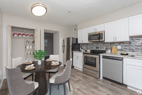 A modern kitchen with a dining table set for two.