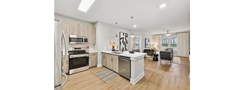 A modern kitchen with wooden cabinets and stainless steel appliances.
