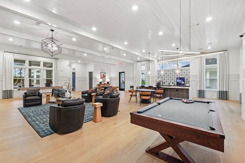 A billiard table is in the middle of a spacious room with a pool table.