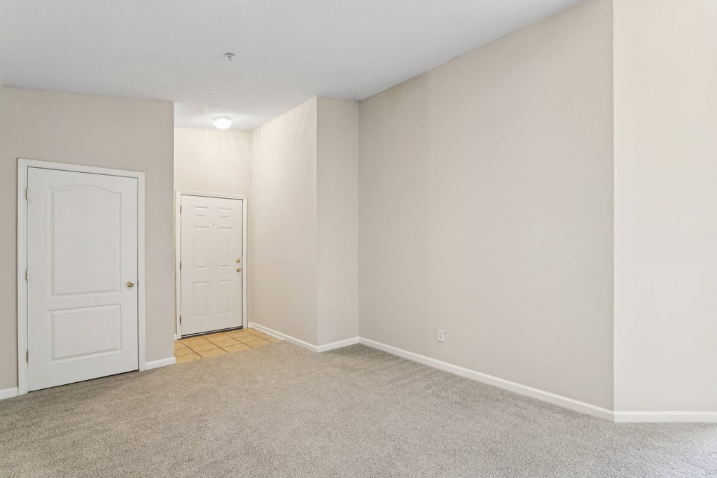 an empty room with white walls and a door to a closet