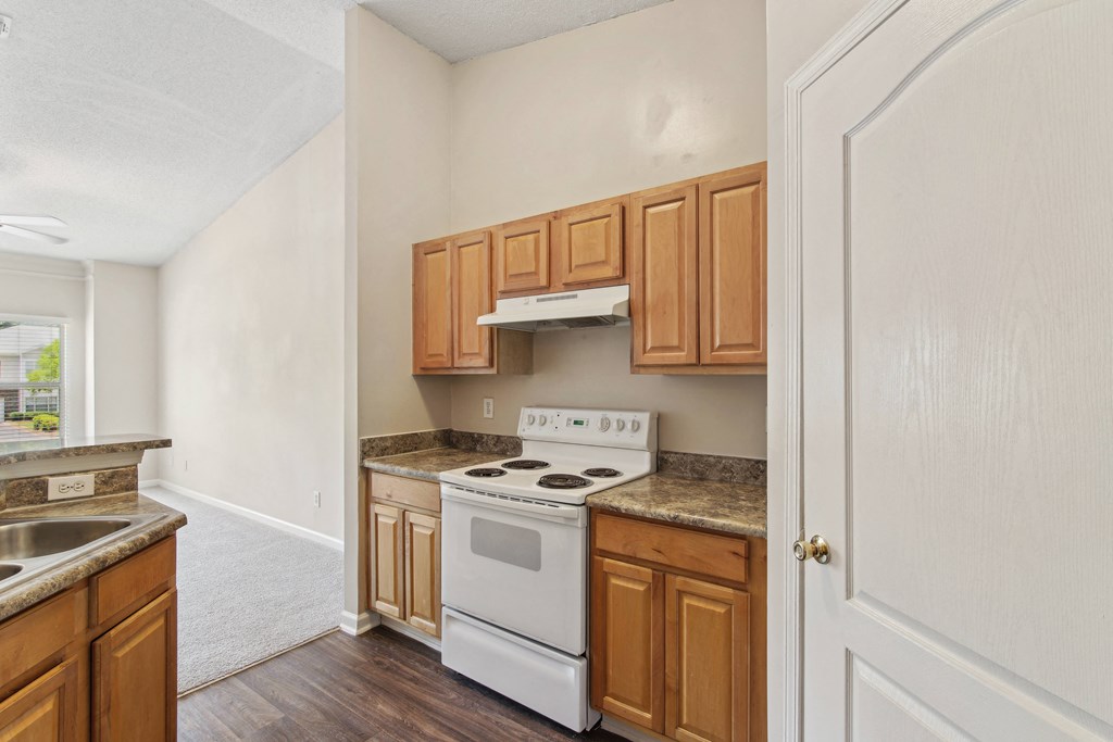 an empty kitchen with wooden cabinets and white appliances
