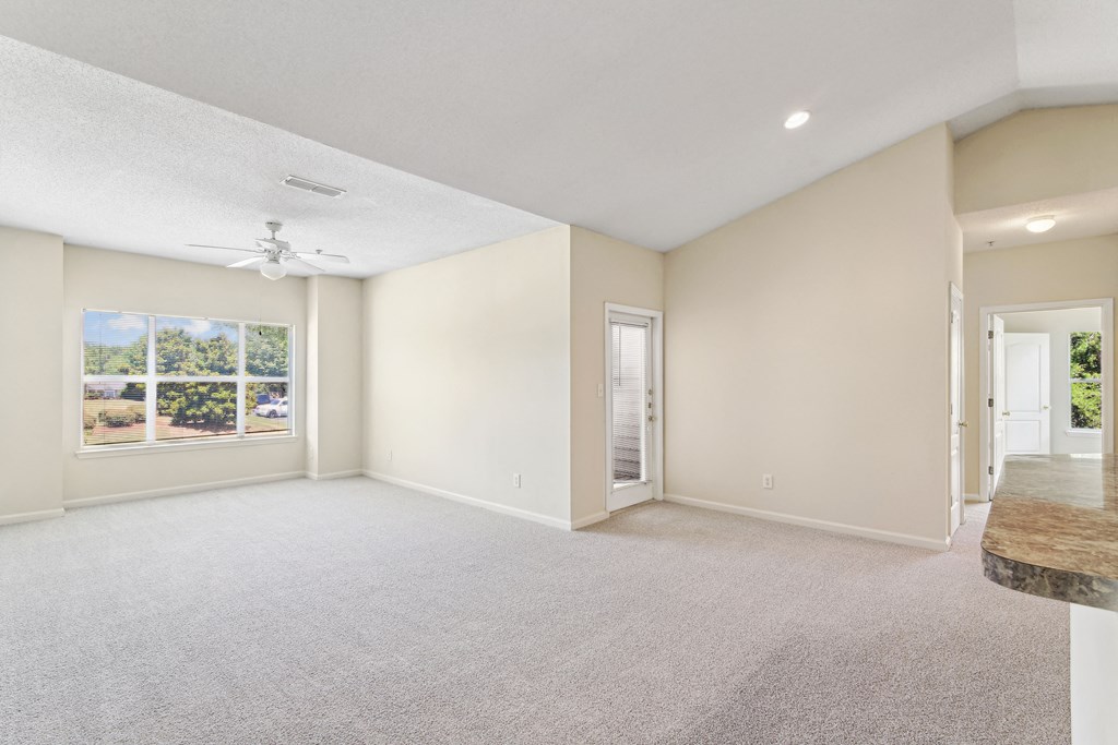 an empty living room with a window and a door