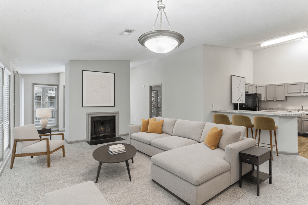A living room with a grey couch, a coffee table, and a fireplace.