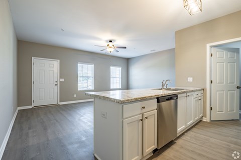 A kitchen with white cabinets and a marble countertop.