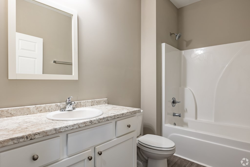 A bathroom with a sink, toilet, and bathtub at Club Villas Apartments, Kathleen, GA