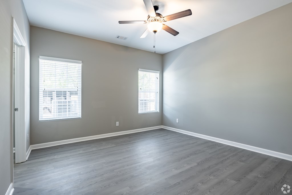 A room with a ceiling fan and two windows at Club Villas Apartments, Georgia, 31047