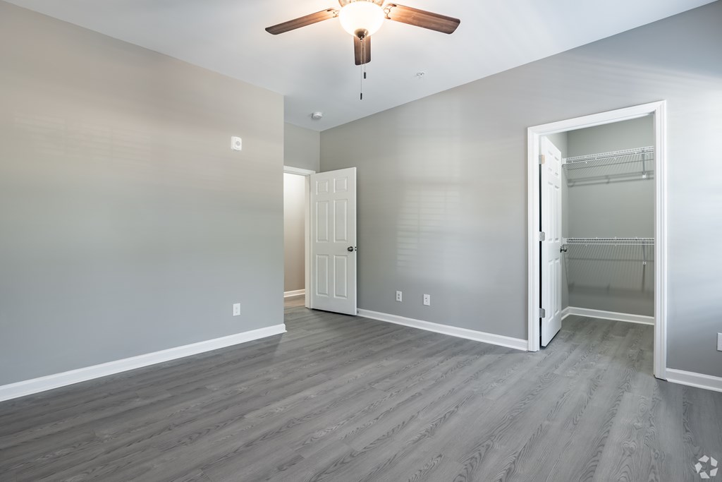 A room with a ceiling fan and a door leading to another room at Club Villas Apartments, Kathleen, Georgia