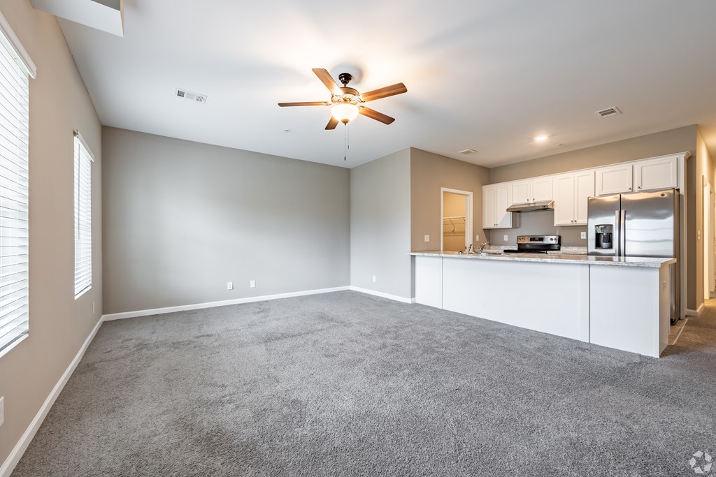 A spacious living room with a ceiling fan and a kitchen area in the background at Club Villas Apartments, Kathleen, 31047