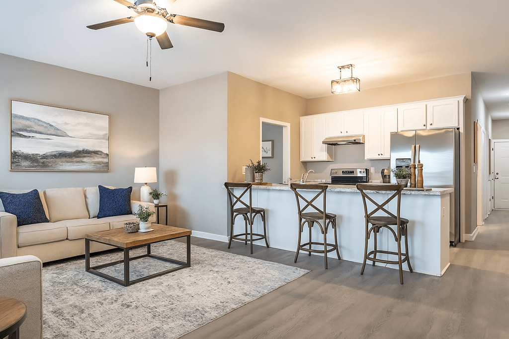 A living room with a couch, a coffee table, and a ceiling fan.