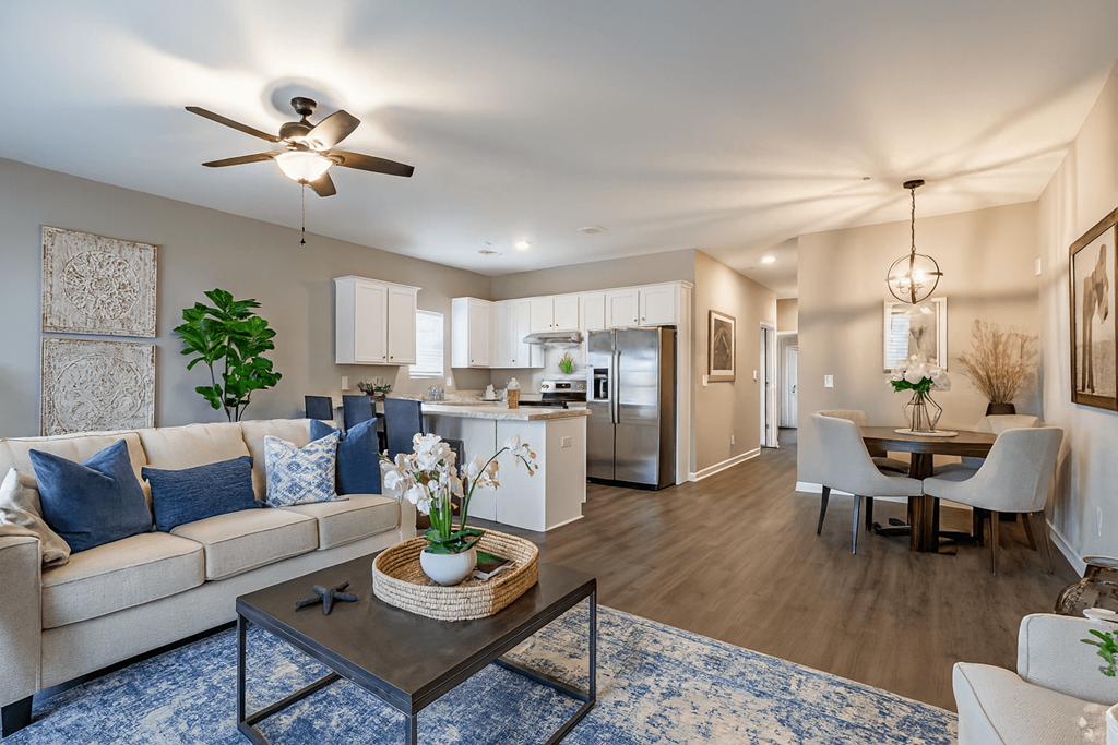 A living room with a couch, a coffee table, and a ceiling fan  at Club Villas Apartments, Kathleen, GA, 31047