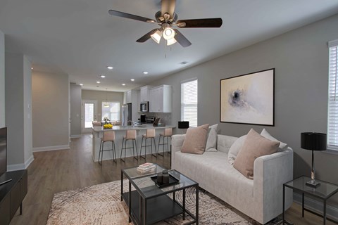 A living room with a white couch and a ceiling fan.