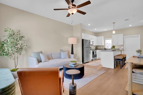 A living room with a brown chair and a ceiling fan.